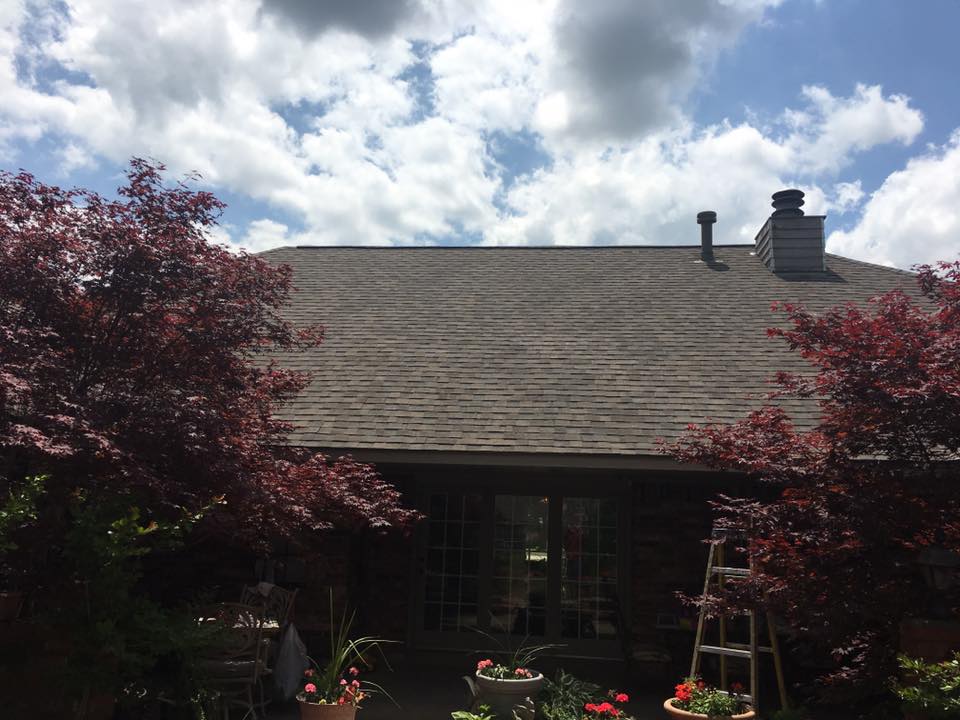 Completed shingle roof with chimney and vent pipe