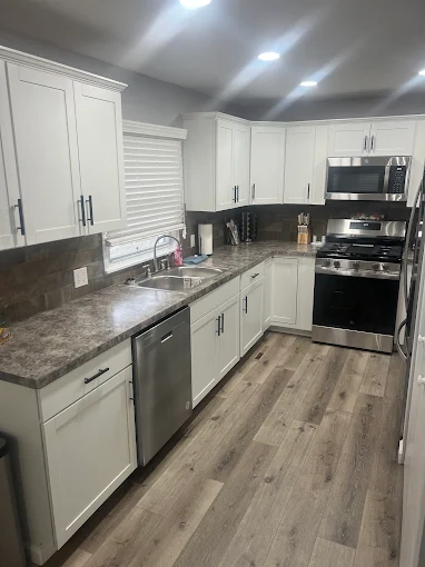 Completed kitchen remodel with white cabinets and granite countertops